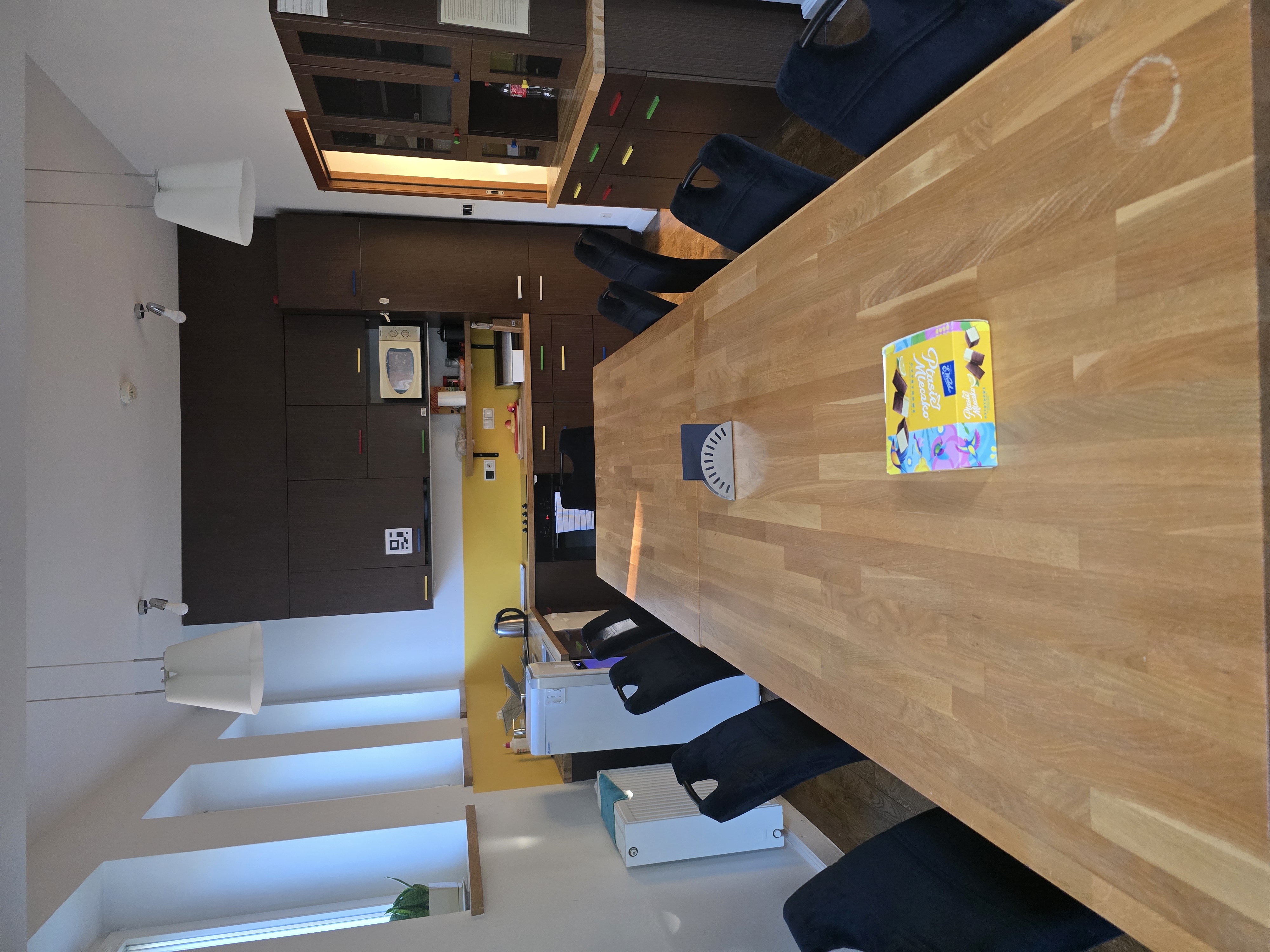 Duży stół z dwunastoma miejscami oraz aneks kuchenny w Domu Dolańskiego